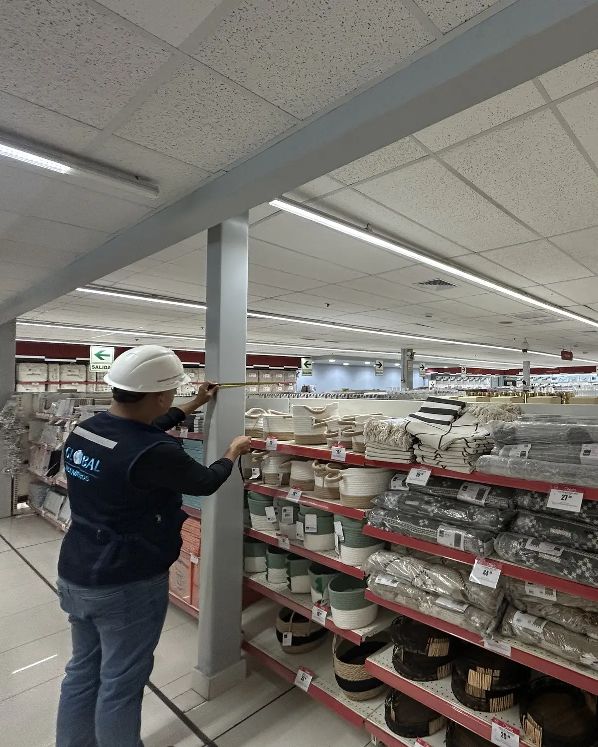 Ingeniero de Global Ingenieros midiendo la estructura de una estantería en una tienda